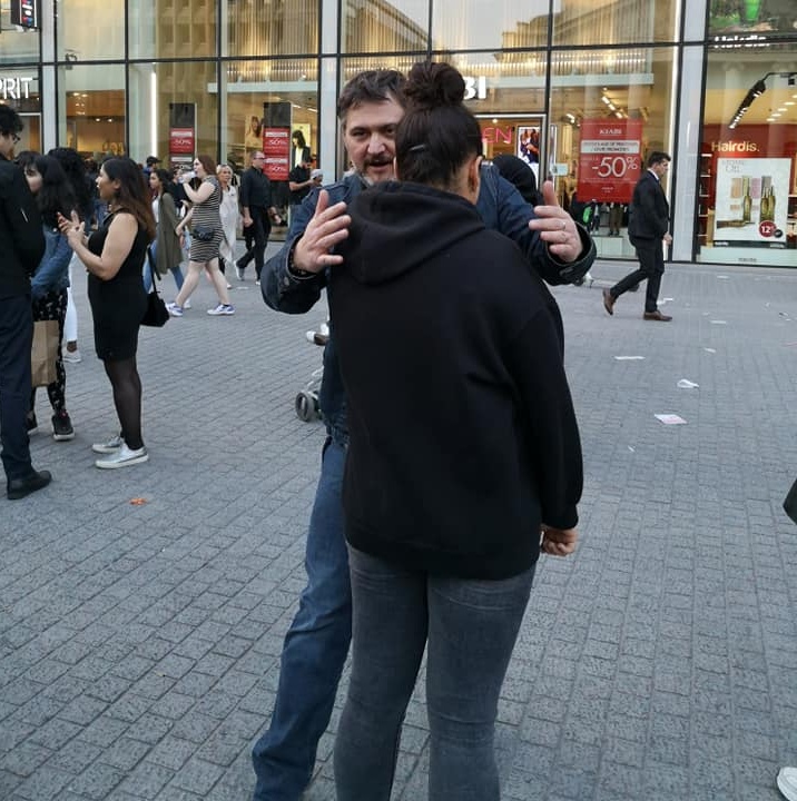 Séance d'hypnose de rue avec étreinte thérapeutique entre hypnotiseur et participant volontaire